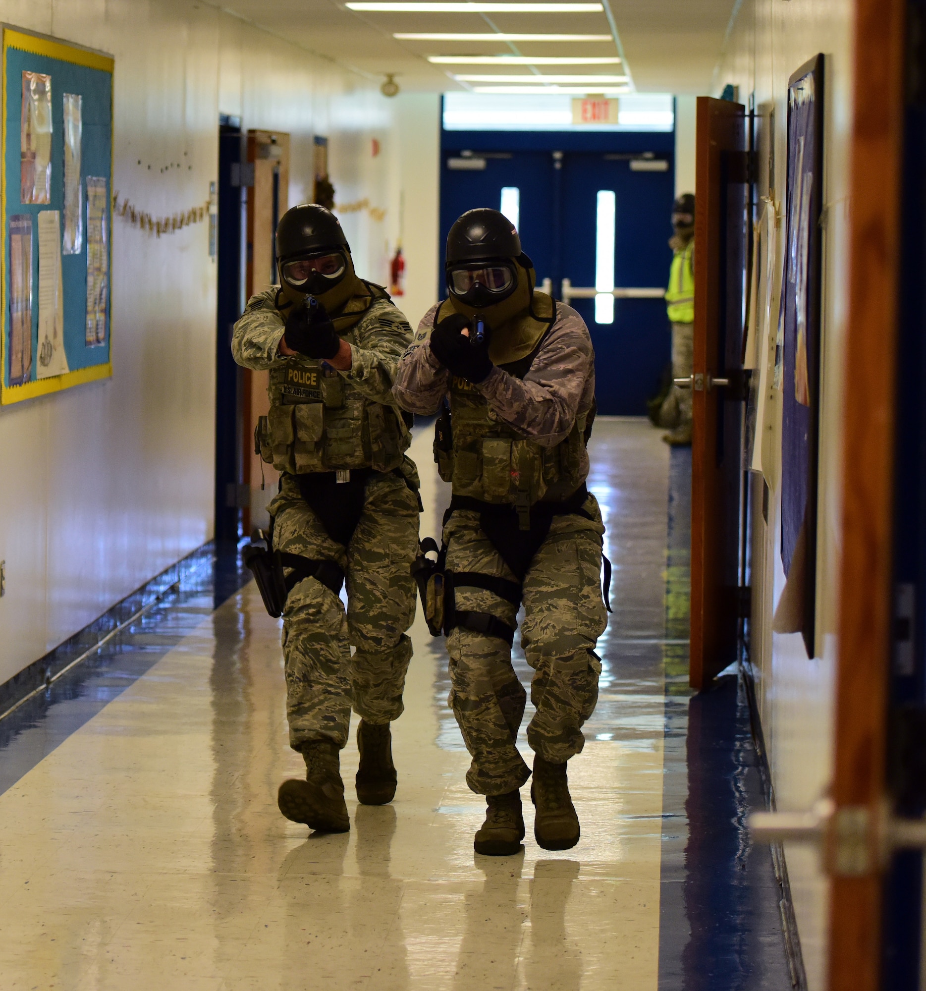 U.S. Air Force Defenders from the 325th Security Forces Squadron move toward the sound of simulated gunfire during an active -shooter training exercise at Tyndall Elementary School outside of Tyndall Air Force Base, Florida, July 30, 2018. The exercise allowed Tyndall defenders the opportunity to train in simulated real-world scenarios in a new setting, aiding them in their execution of force protection programs. The squadron oversees personnel, information, and industrial security procedures for more than 6,700 assigned personnel. (U.S. Air Force photo by Senior Airman Isaiah J. Soliz)