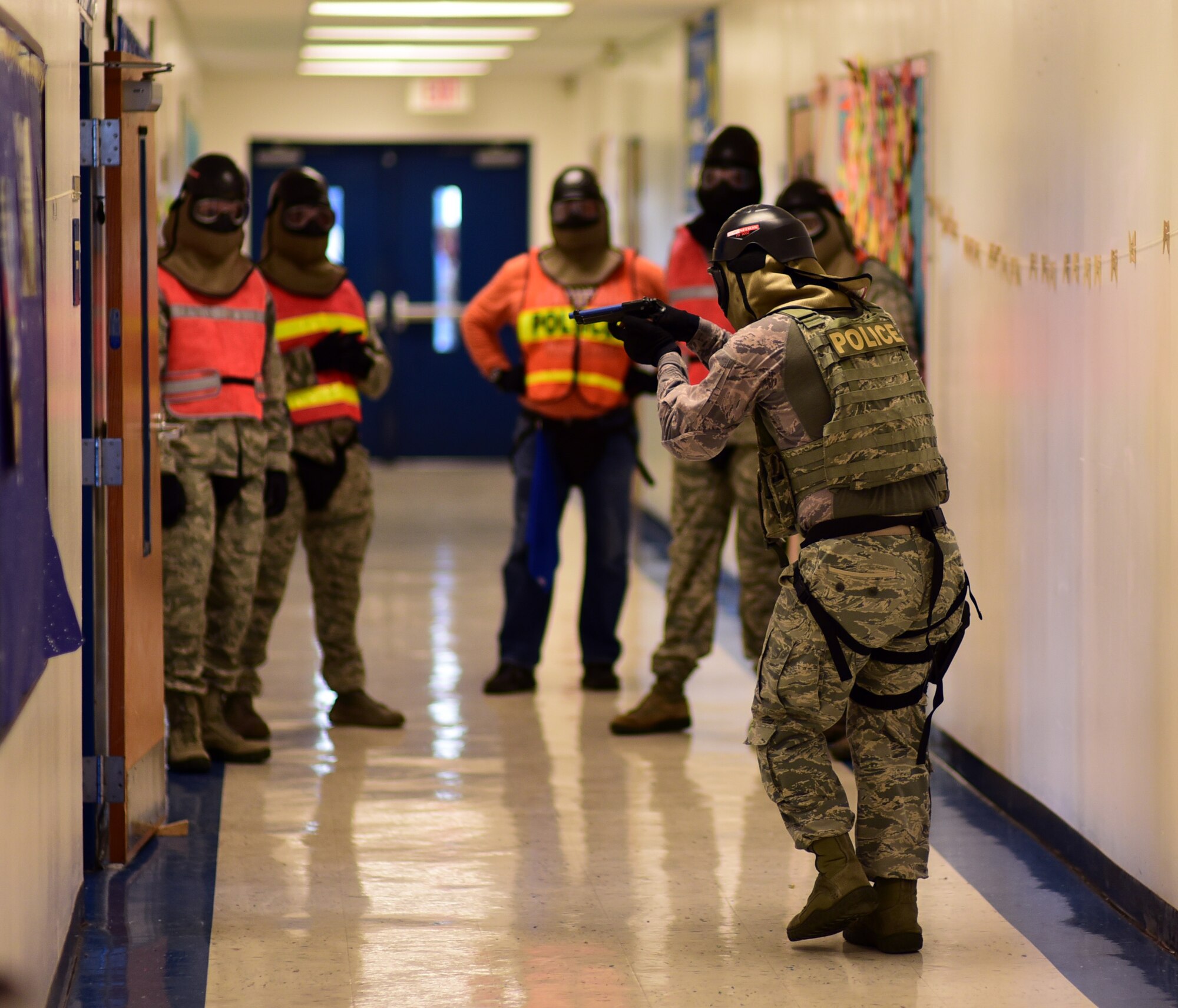 U.S. Air Force senior leadership and exercise evaluators observe as Tech. Sgt. Eric Lawrence, 325th Security Forces Squadron flight chief, tactically approaches a doorway during an active -shooter training exercise at Tyndall Elementary School outside of Tyndall Air Force Base, Florida, July 31, 2018. The exercise allowed Team Tyndall defenders to approach simulated real-world scenarios in a new environment. Tyndall defenders perform a plethora of duties to include: law enforcement, installation security, pass and registration, military working dog, anti -terrorism, resource protection and installation security services. (U.S. Air Force photo by Senior Airman Isaiah J. Soliz)