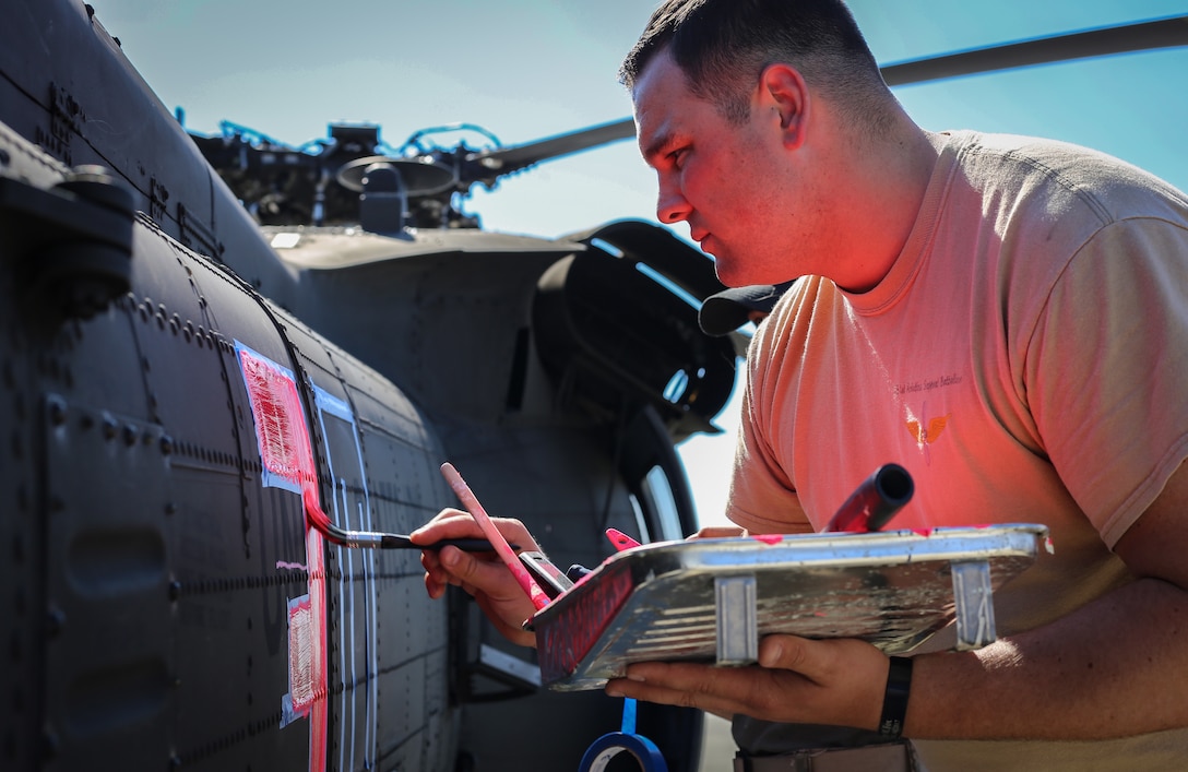 Army Spc. Nicholas Ehrenheim paints a UH-60 Black Hawk helicopter fluorescent pink in preparation for wildfire support, July 31, 2018. The painted sections will make the helicopter stand out from the green background of the forest, helping them remain visible from the ground and air. Ehrenheim is assigned to the Washington Army National Guard’s Bravo Company, 351st Aviation Support Battalion. Washington Army National Guard photo by Sgt. 1st Class Jason Kriess