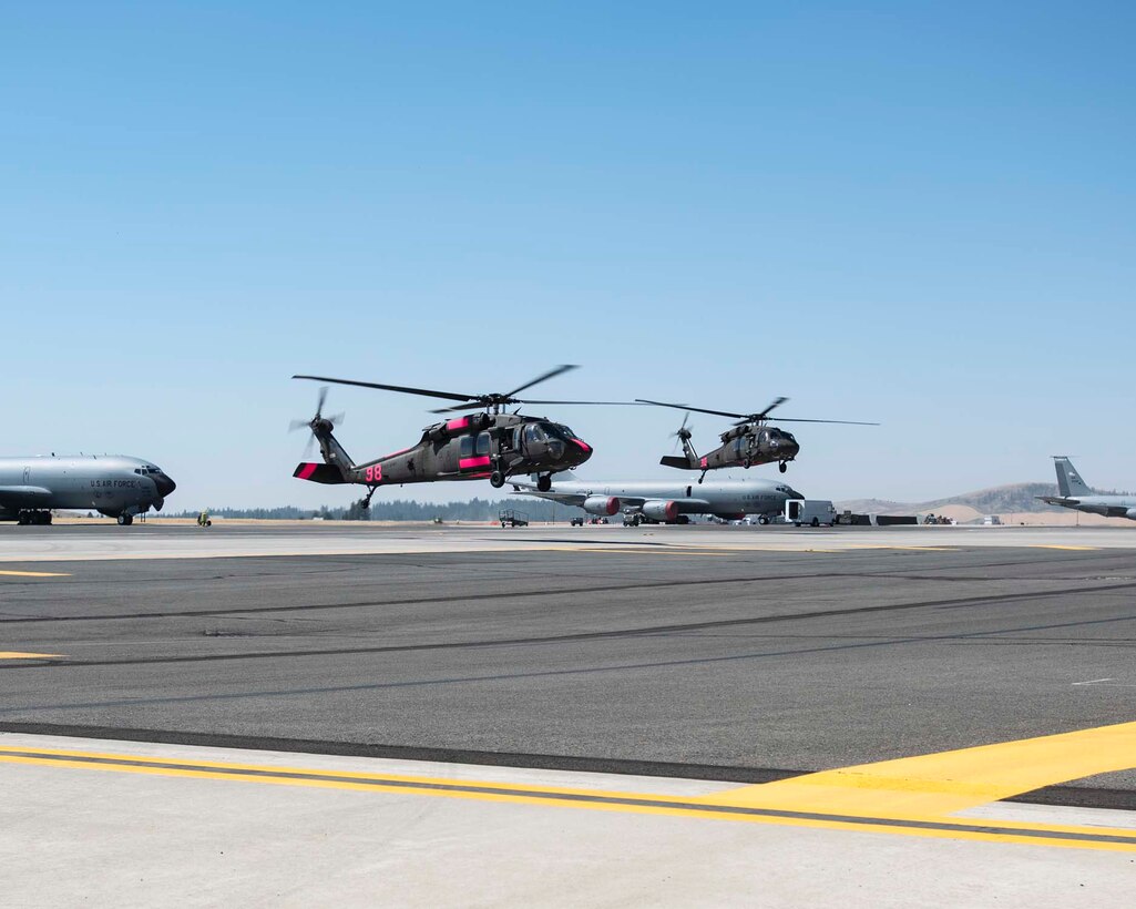 Two Black Hawk helicopters from Joint-Base Lewis-McChord land at Fairchild Air Force Base, Wash. in support of firefighting efforts in eastern Washington August 1, 2018. The helicopters will primarily be used as water buckets and can carry nearly 660 gallons of water at one time. (U.S. Air National Guard photo by Tech. Sgt. Michael Brown)