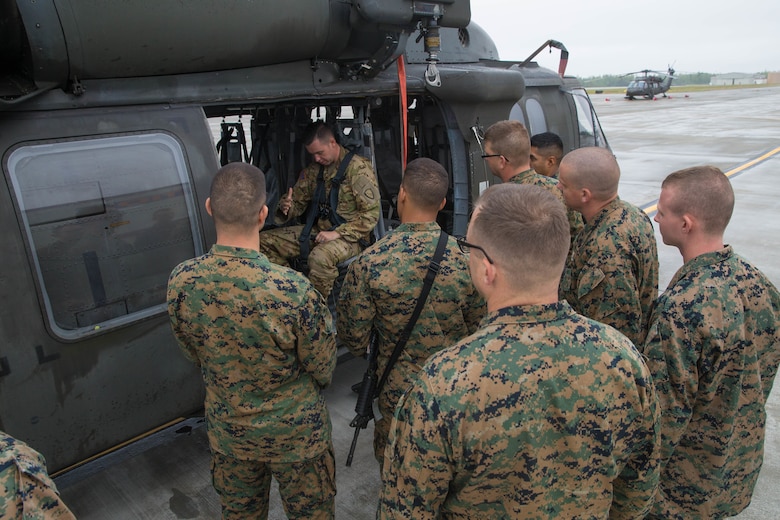 Squad Leaders and select support staff, from the 4th Marine Division Annual Rifle Squad competition, receive lessons on how to properly board and ride in a U.S. Army Sikorsky UH-60 Black Hawk at Joint Base Elmendorf-Richardson, Anchorage, Alaska, August 1, 2018. Squad leaders from the Annual Rifle Squad Competition were air-lifted throughout the training sites in order to conduct route reconnaissance before the commencement of the four day competition. (U.S. Marine Corps photo by Lance Cpl. Samantha Schwoch/released)