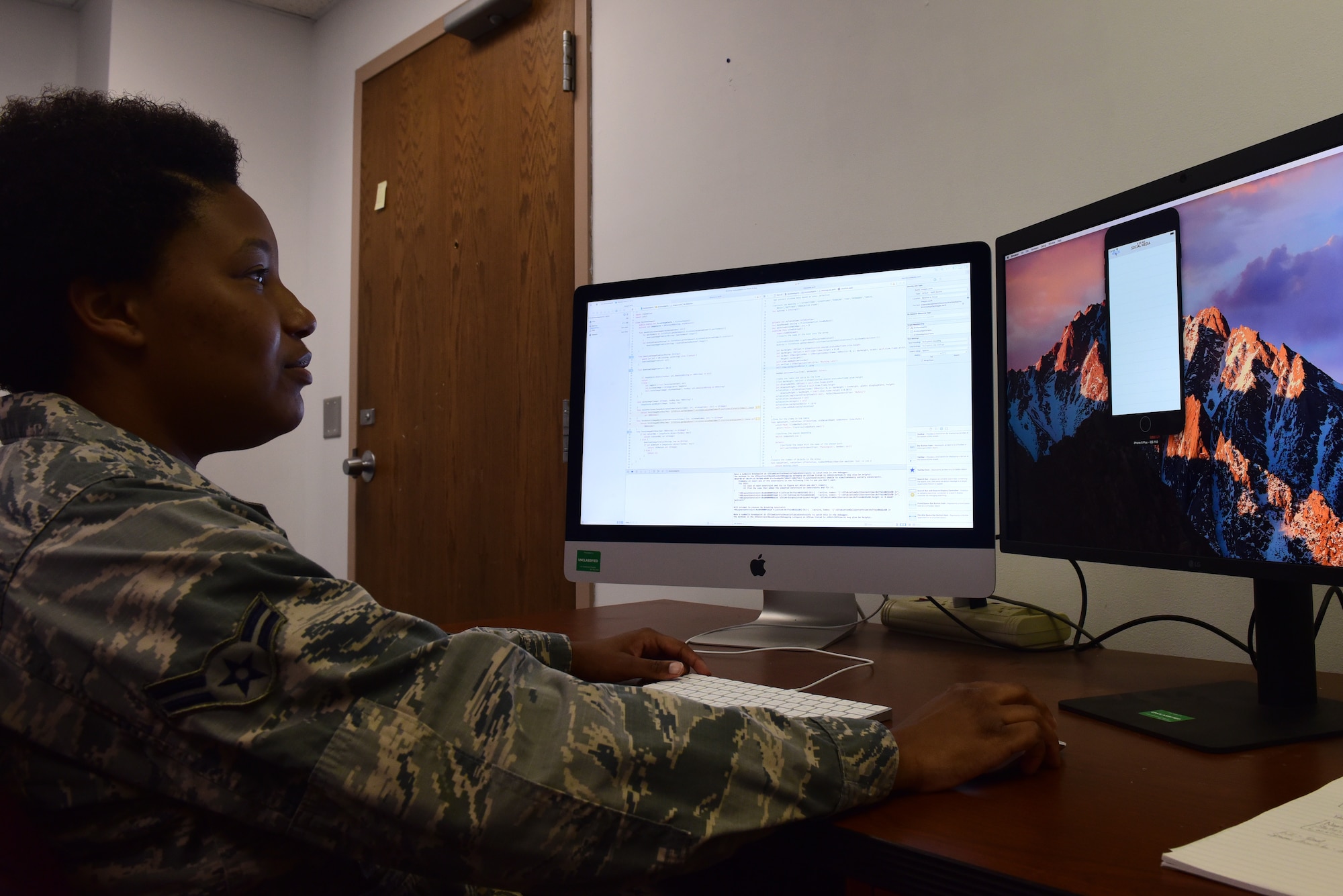 Airman 1st Class Ebony Crawford, 595th Strategic Communication Squadron strategic software programmer, who led the iPhone programming section for the 2018 Air and Space Show app, reviews the code for the program June 6, 2018, at Offutt Air Force Base, Nebraska. This year’s app will involve live updates on parking and performers. (U.S. Air Force photo by Staff Sgt. Rachel Hammes)