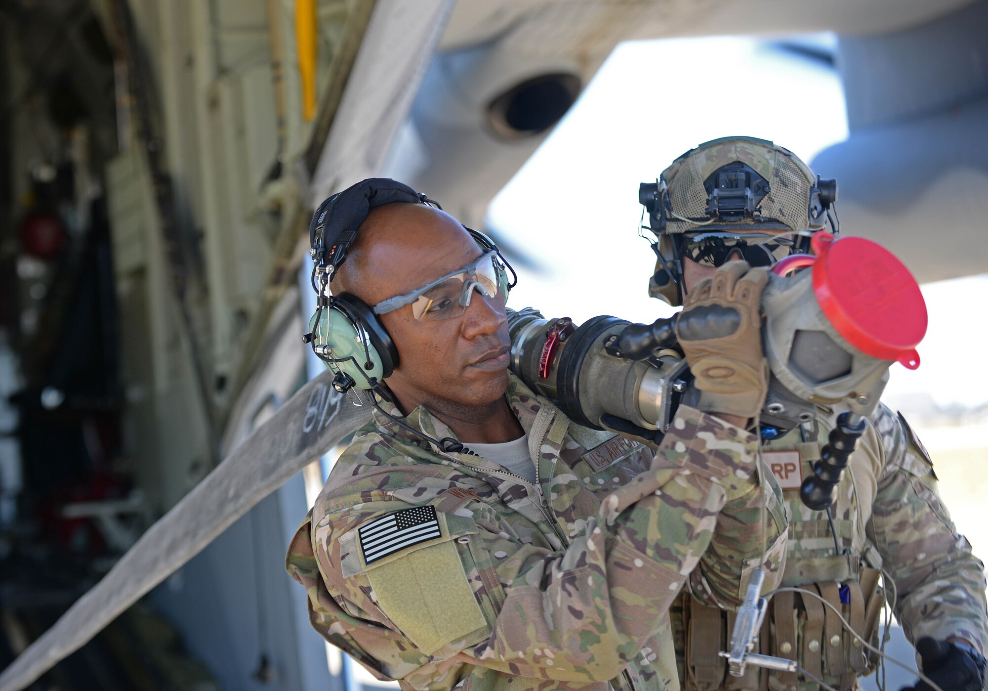 Chief Master Sgt. of the Air Force Kaleth O. Wright carries a fuel hose from a MC-130J II Commando during a Forward Area Refueling Point exercise at RAF Mildenhall, England, Aug. 2, 2018. During the visit, Wright met with Airmen from multiple units to ask about their needs and see how they accomplish the mission. (U.S. Air Force photo by Senior Airman Luke Milano)