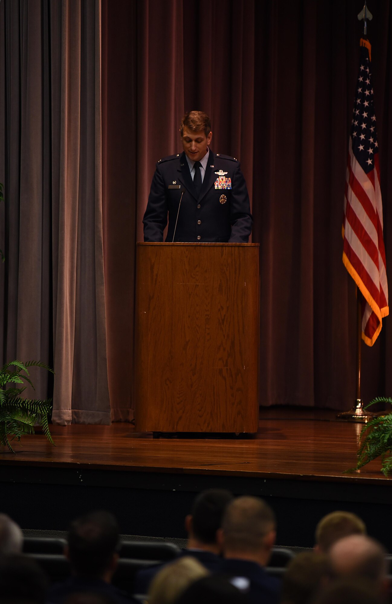 Col. David Gordon, 2nd Operations Group commander at Barksdale Air Force Base, Louisiana, speaks to Specialized Undergraduate Pilot Training Class 18-12 July 27, 2018, on Columbus Air Force Base, Mississippi. Gordon earned his silver wings in the same auditorium roughly 20 years ago and he remarked his excitement to be back and noted the base felt comfortably familiar during the graduation festivities. (U.S Air Force photo by Airman 1st Class Keith Holcomb)