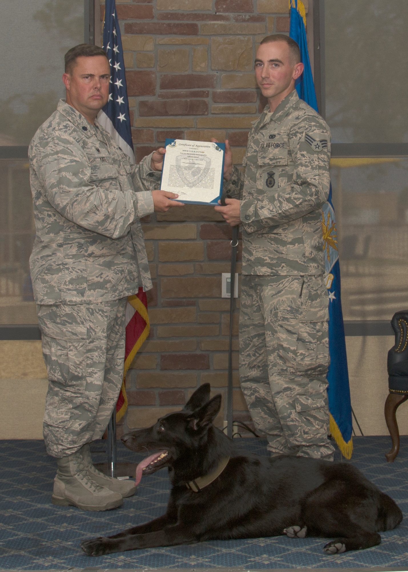 Vulkan, military working dog for the 49th Security Forces Squadron, receives a certificate of appreciation during his retirement ceremony at Holloman Air Force Base, N.M., July 27, 2018. Vulkan contributed to securing and defending 17,000 personnel that live and work on Holloman.