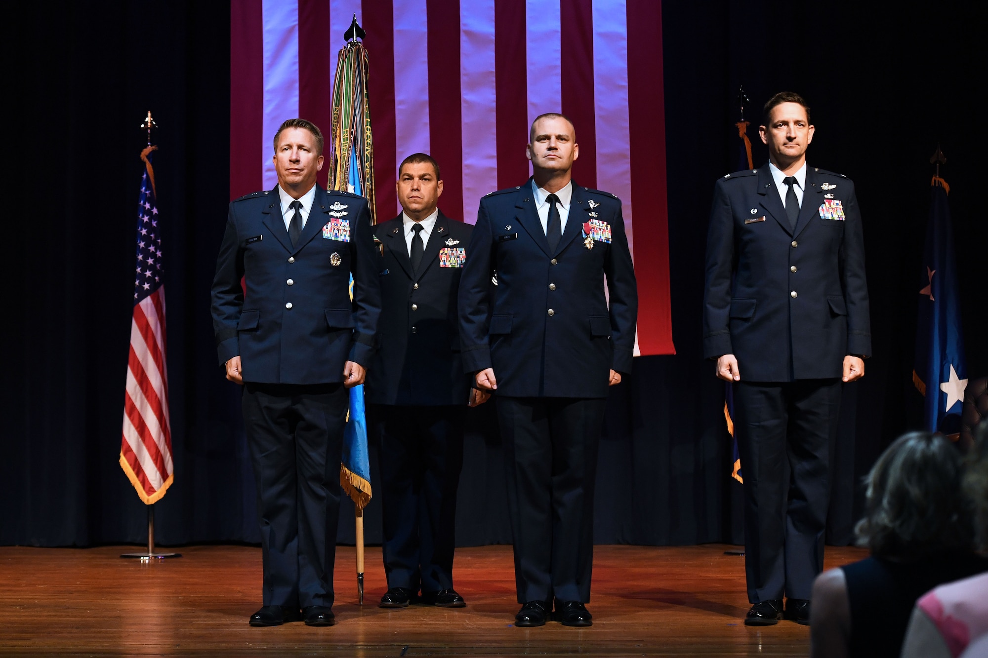 Four men stand at attention.