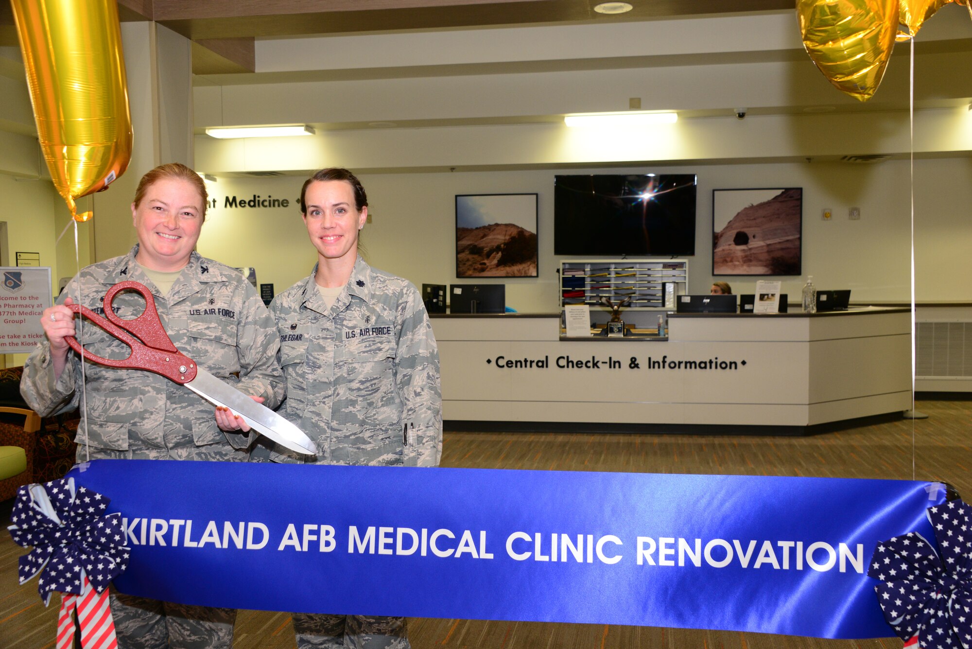 377th Medical Group Command Col. Mary Stewart (left) and Deputy Command Lt. Col. Amanda Phlegar prepare for a ceremonial ribbon cutting Aug. 1 at the Base Hospital. The ceremonial ribbon was s symbolic gateway to the new customer service focal point, a check-in and information center on the first floor. (U.S. Air Force photo by Jessie Perkins)