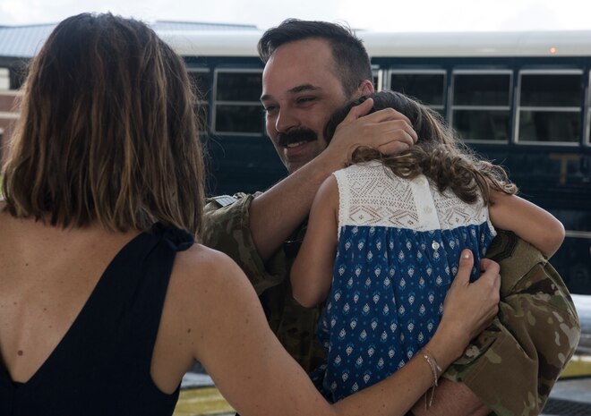 Maj. Ben Buxton, 16th Airlift Squadron assistant director of operations, is reunited with his family August 2, 2018, at Joint Base Charleston S.C.The 16th AS Airmen managed to complete a total of 1,045 sorties over a span of 2,212 hours, moving 35.6 million pounds of cargo to include 4,980 pallets and 10,914 passengers during their three-month tour in the Air Force Central Command area of responsibility.