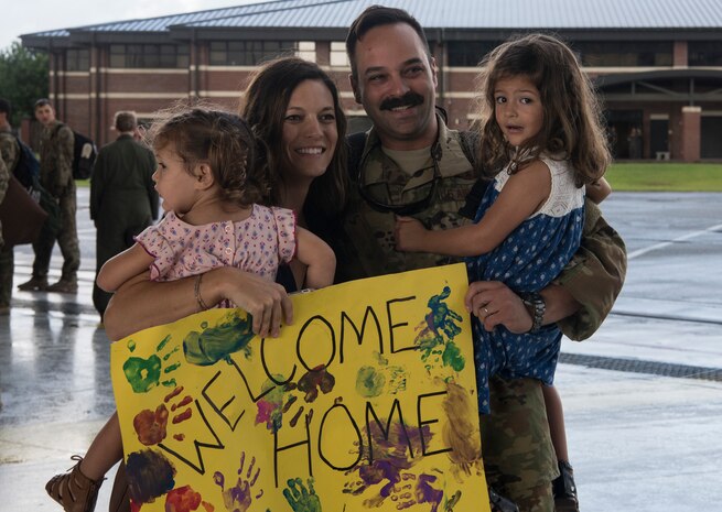 Maj. Ben Buxton, 16th Airlift Squadron assistant director of operations, is reunited with his family Aug. 2, 2018, at Joint Base Charleston S.C. The 16th AS Airmen managed to complete a total of 1,045 sorties over a span of 2,212 hours, moving 35.6 million pounds of cargo to include 4,980 pallets and 10,914 passengers during their three-month tour in the Air Force Central Command area of responsibility.