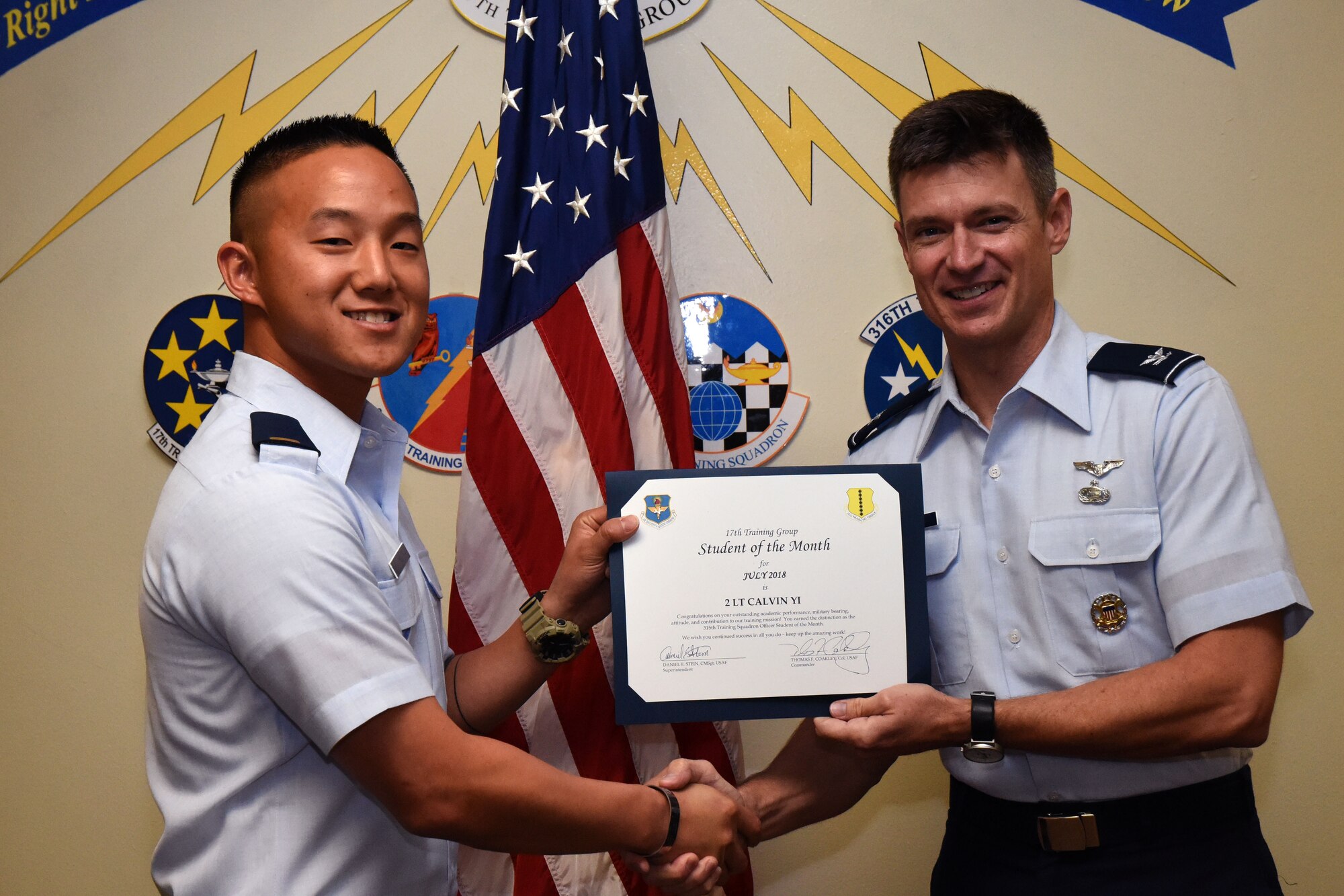 U.S. Air Force 2nd Lt. Calvin Yi, 315th Training Squadron student, receives the 315th Training Squadron Officer Student of the Month award from Col. Thomas Coakley, 17th Training Group commander, at Brandenburg Hall on Goodfellow Air Force Base, Texas, Aug. 3, 2018. The 315th TRS vision is to develop combat-ready intelligence, surveillance and reconnaissance professionals and promote an innovative squadron culture and identity unmatched across the U.S. Air Force. (U.S. Air Force photo by Airman 1st Class Seraiah Hines/Released)