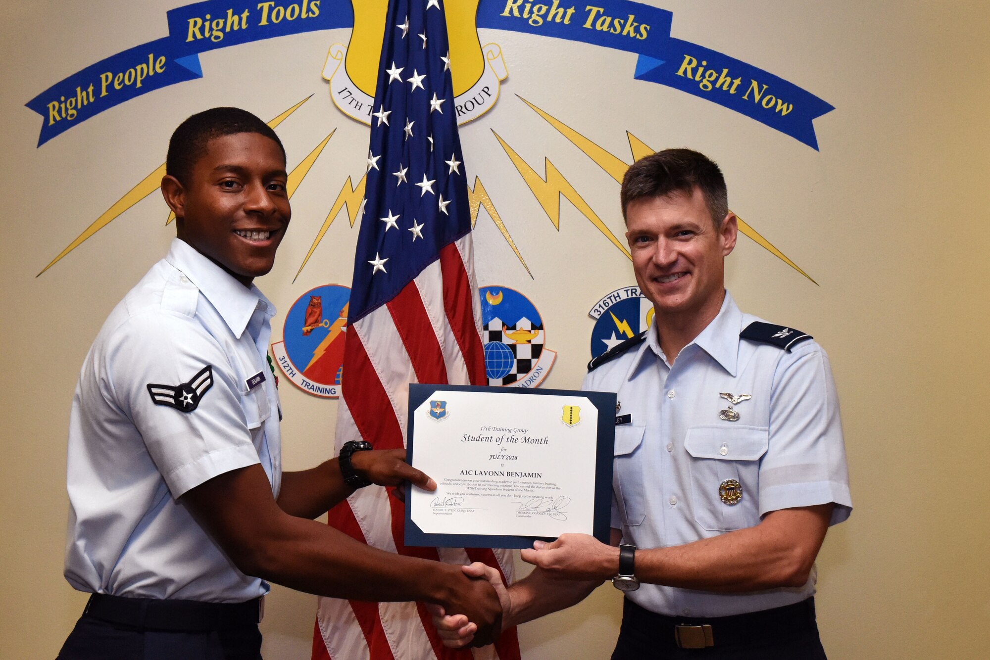 U.S. Air Force Airman 1st Class Lavonn Benjamin, 312th Training Squadron student, receives the 312th Training Squadron Student of the Month award from Col. Thomas Coakley, 17th Training Group commander, at Brandenburg Hall on Goodfellow Air Force Base, Texas, Aug. 3, 2018. The 312th TRS mission is to provide Department of Defense and international customers with mission ready fire protection and special instruments graduates and provide mission support for the Air Force Technical Applications Center. (U.S. Air Force photo by Airman 1st Class Seraiah Hines/Released)