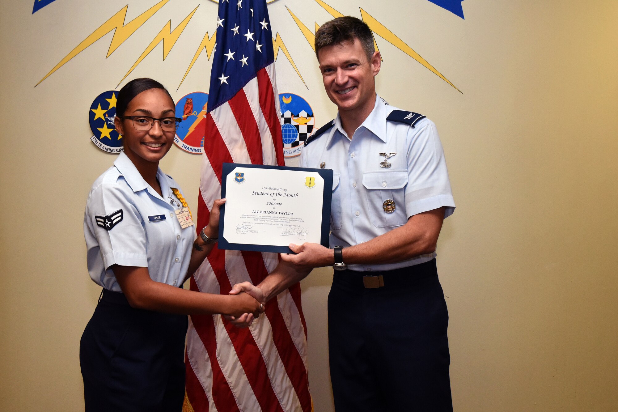 U.S. Air Force Airman 1st Class Brianna Taylor, 315th Training Squadron student, receives the 315th Training Squadron Student of the Month award from Col. Thomas Coakley, 17th Training Group commander, at Brandenburg Hall on Goodfellow Air Force Base, Texas, Aug. 3, 2018. The 315th TRS vision is to develop combat-ready intelligence, surveillance and reconnaissance professionals and promote an innovative squadron culture and identity unmatched across the U.S. Air Force. (U.S. Air Force photo by Airman 1st Class Seraiah Hines/Released)