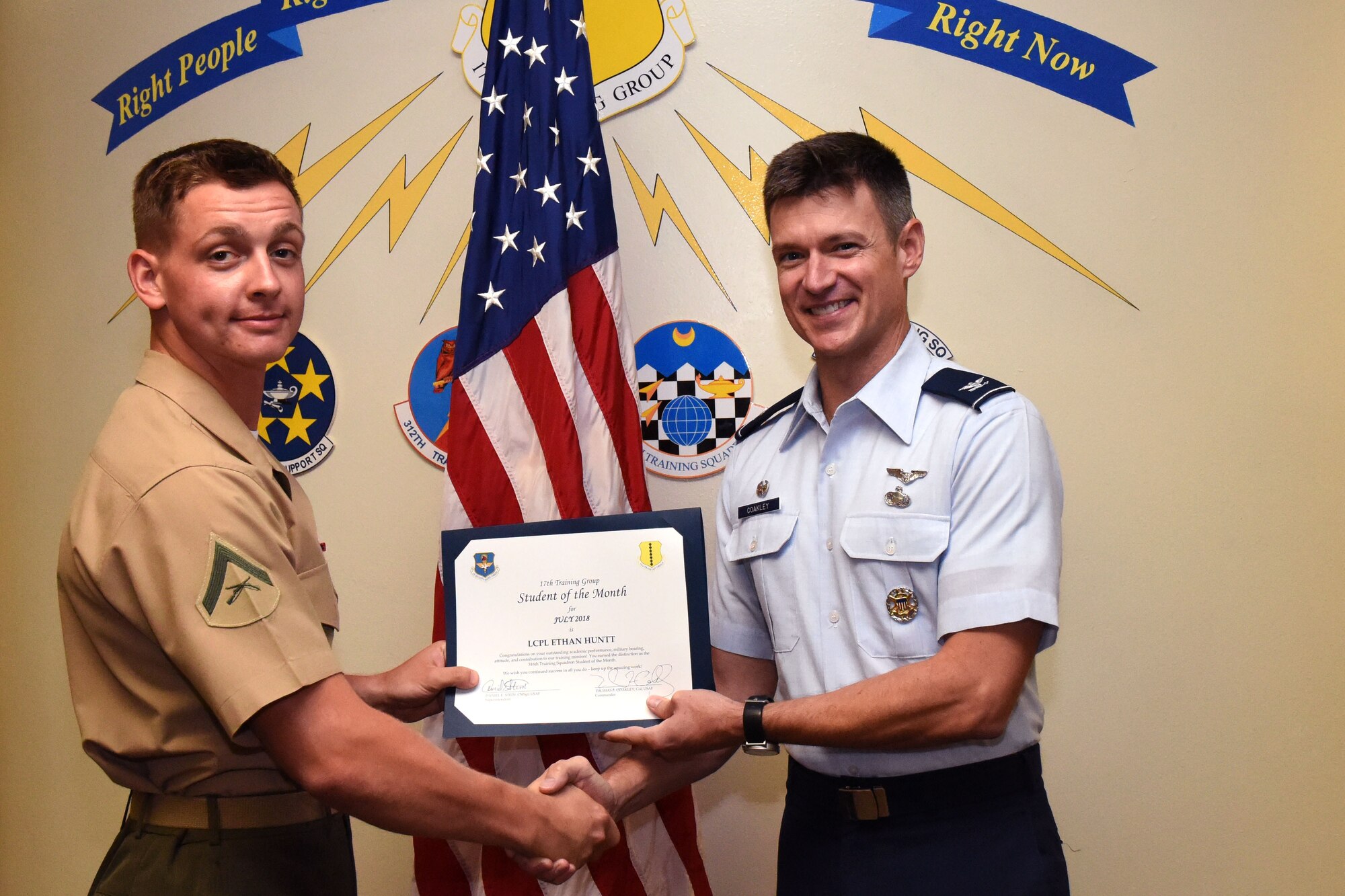 U.S. Marine Corp Lance Cpl. Ethan Huntt, 316th Training Squadron trainee, receives the 17th Training Group Student of the Month award from Col. Thomas Coakley, 17th Training Group commander, at Brandenburg Hall on Goodfellow Air Force Base, Texas, Aug. 3, 2018. The 316th TRS mission is to conduct Department of Defense cryptologic, human intelligence and military training. (U.S. Air Force photo by Airman 1st Class Seraiah Hines/Released)