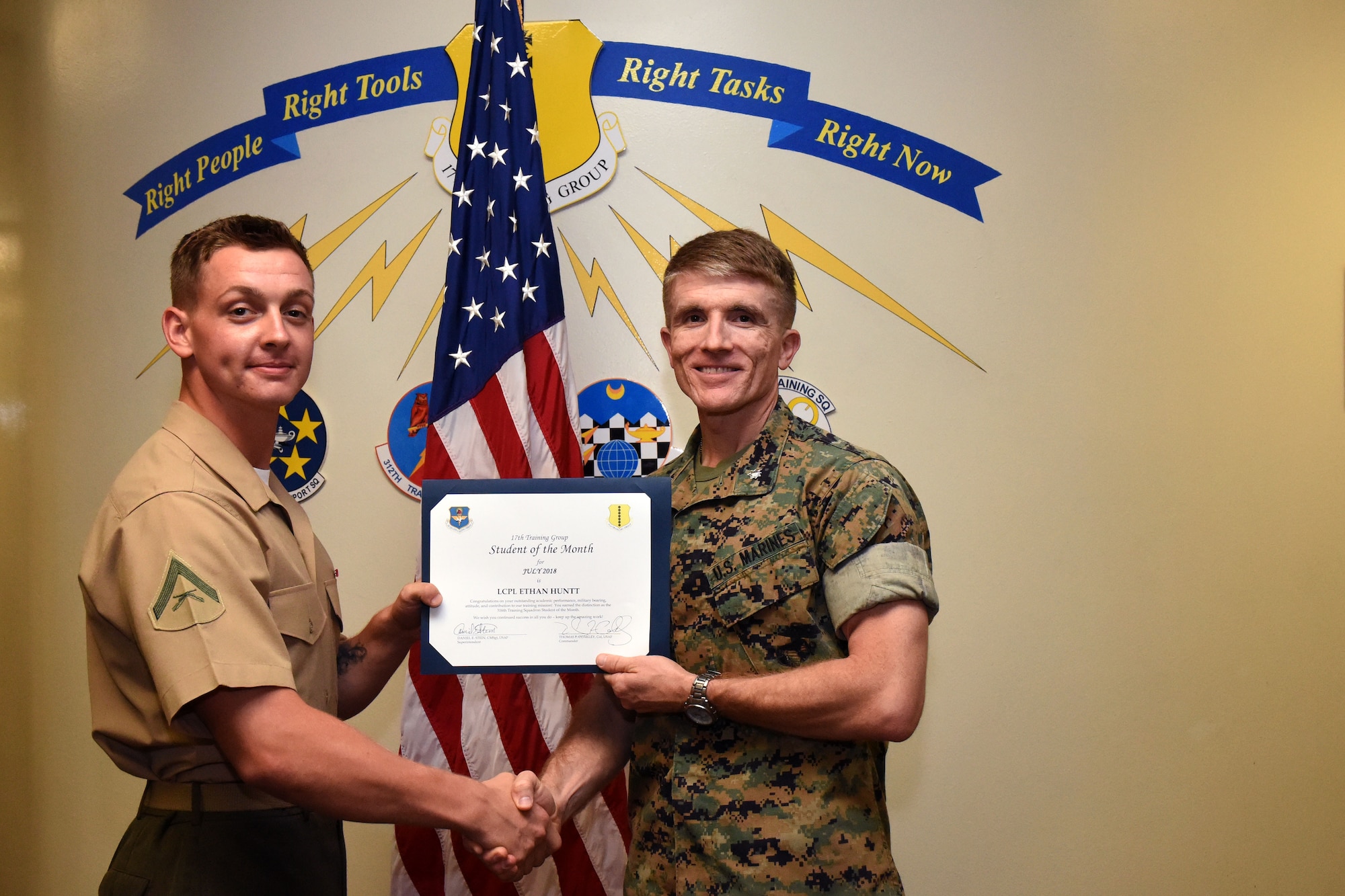 The 17th Training Group Student of the Month spotlight for July 2018, U.S. Marine Corp Lance Cpl. Ethan Huntt, 316th Training Squadron student, holds his award with Lt. Col. Earl Patterson, Marine Corps Detachment at Goodfellow commander, at Brandenburg Hall on Goodfellow Air Force Base, Texas, Aug. 3, 2018. Huntt is the Goodfellow Student of the Month spotlight for July 2018, a series highlighting Goodfellow students. (U.S. Air Force photo by Airman 1st Class Seraiah Hines/Released)