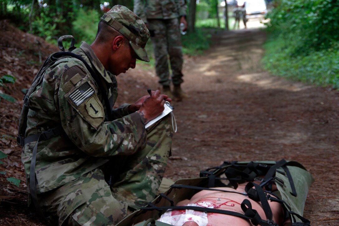 A soldier writes down medical notes.