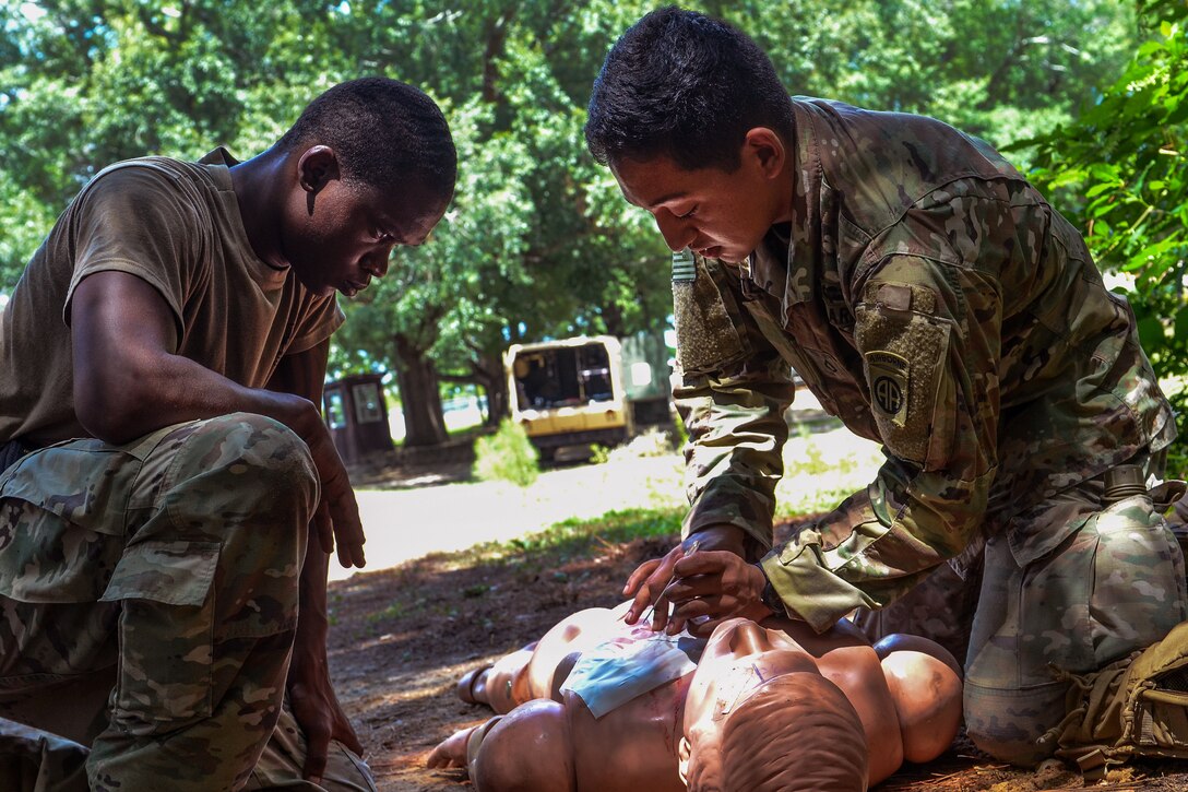 A soldier provides medical aid to a mock casualty victim.