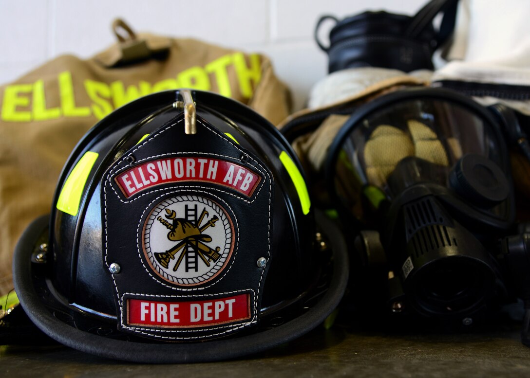 A firefighter’s gear is displayed inside the fire department at Ellsworth Air Force Base, S.D., July 31, 2018. A typical firefighting kit includes a turnout jacket and trousers, boots, helmet, self-contained breathing apparatus, and a protective hood. (U.S. Air Force photo by Senior Airman Denise M. Jenson)