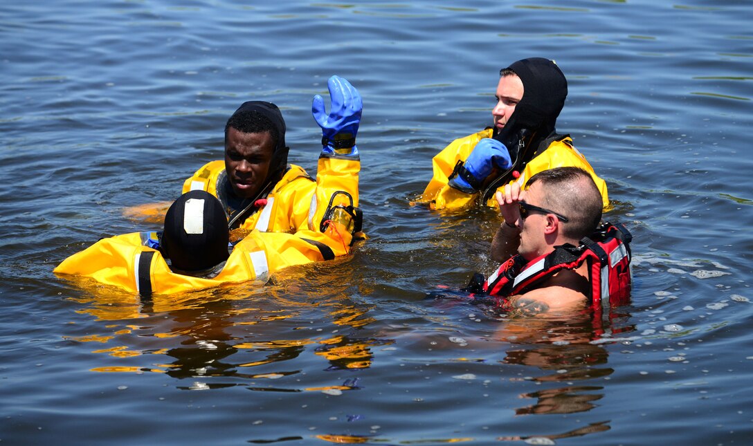 Senior Airman Thomas Hill, a 28th Civil Engineer Squadron fire fighter, left, practices rescuing a drowning person during a water rescue training session in the base lakes on Ellsworth Air Force Base, S.D., July 31, 2018. When firefighters are called out to a water rescue, they must ensure they wear the proper personal floatation device. (U.S. Air Force photo by Senior Airman Denise M. Jenson)