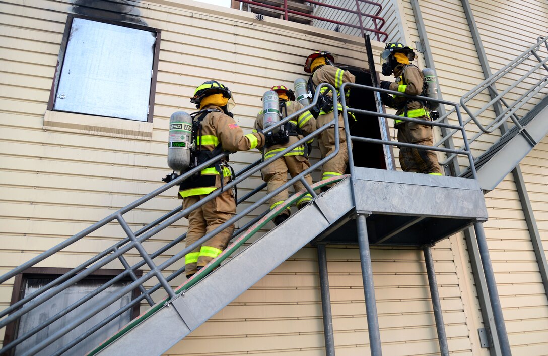 A team of firefighters from the South Dakota National Guard and Ellsworth Air Force Base, S.D., prepare to enter a building during a nighttime fire training session at Ellsworth AFB, Aug. 2, 2018. Ellsworth AFB’s fire department often conducts joint training missions with both local fire departments and the South Dakota National Guard. (U.S. Air Force photo by Senior Airman Denise M. Jenson)