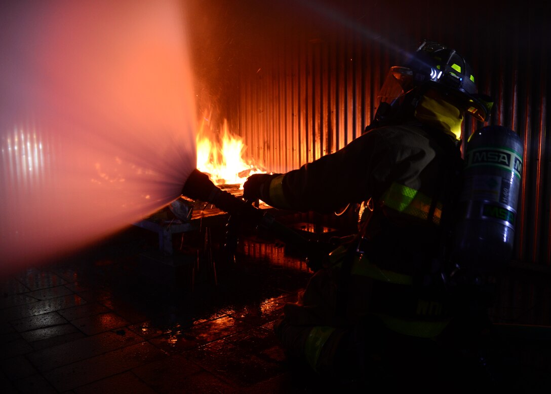 A Soldier with the South Dakota National Guard puts out a fire during a nighttime fire training session at Ellsworth Air Force Base, S.D., Aug. 2, 2018. Ellsworth AFB’s fire department often conducts joint training missions with both local fire departments and the South Dakota National Guard. (U.S. Air Force photo by Senior Airman Denise M. Jenson)