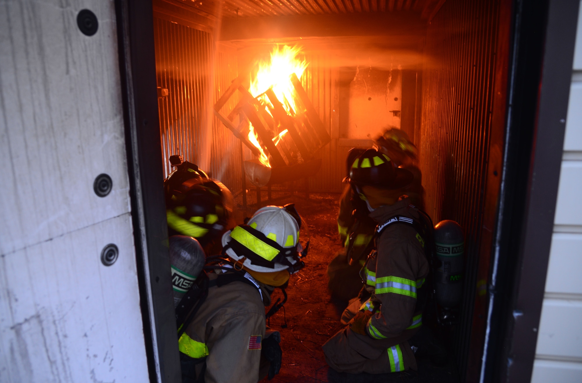 A team of firefighters from the South Dakota National Guard and Ellsworth Air Force Base, S.D., watches as a fire blazes during a nighttime fire training session at Ellsworth AFB, Aug. 2, 2018. Ellsworth AFB’s fire department often conducts joint training missions with both local fire departments and the South Dakota National Guard. (U.S. Air Force photo by Senior Airman Denise M. Jenson)
