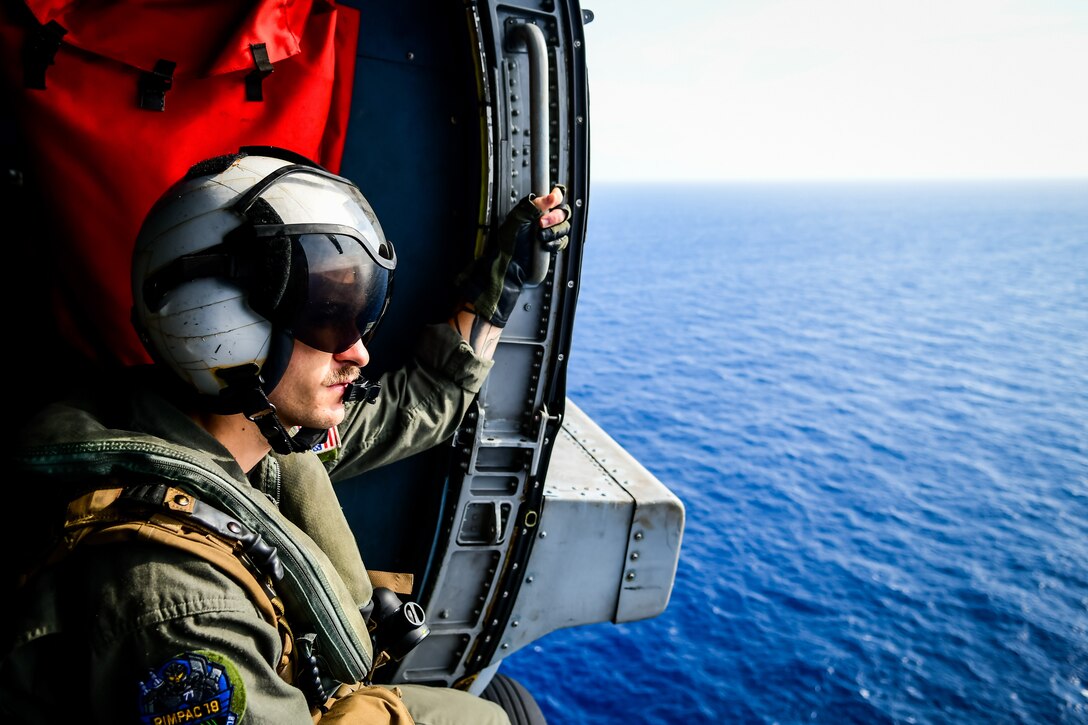 A sailor observes a replenishment-at-sea during the Rim of the Pacific exercise.