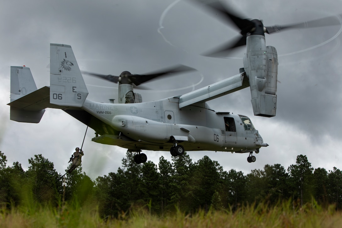 A Marine with Battalion Landing Team, 1st Battalion, 2nd Marines, 22nd Marine Expeditionary Unit fast ropes out of an MV-22 Osprey during the 22nd MEU Deployment for Training at Fort A.P. Hill, VA., July 31, 2018. In preparation for their upcoming deployment, the Marines practiced embassy reinforcement by fast roping onto a rooftop and clearing out a simulated embassy building, which in turn allowed the Marines to train in an urban environment.