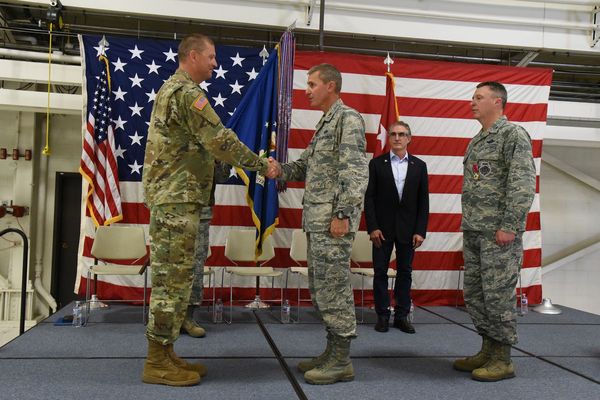 Maj. Gen. Al Dohrmann, the North Dakota adjutant general, left, congratulates Col. Darrin Anderson during a change of command ceremony at the North Dakota Air National Guard Base, Fargo, N.D., Aug. 4, 2018. Anderson is replacing Col. Britt Hatley, far right, the out-going 119th Wing commander.