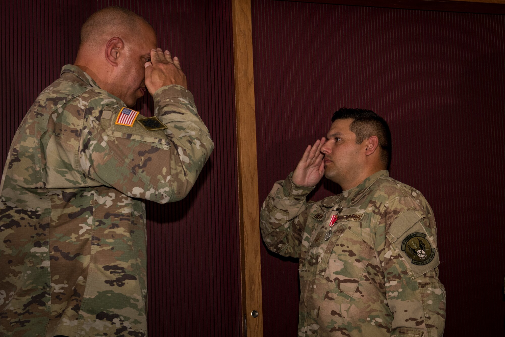 Master Sgt. Adam Hinsperger (left), 285th Special Operations Intelligence Squadron (SOIS) intelligence analyst, salutes Major General Michael Thompson, Adjutant General for Oklahoma, after receving a medal during an award ceremony Aug. 4, 2018, at Will Rogers Air National Guard Base, Oklahoma City.