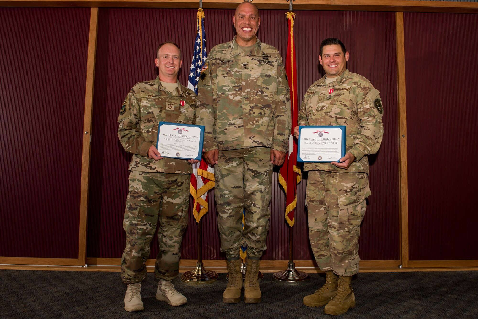 Master Sgt. Casey Ray (left), 285th Special Operations Intelligence Squadron (SOIS) intelligence analyst,  Major General Michael Thompson, Adjutant General for Oklahoma, and Master Sgt. Adam Hinsperger (right), 285th SOIS intelligence analyst, pose during an award ceremony Aug. 4, 2018, at Will Rogers Air National Guard Base, Oklahoma City.