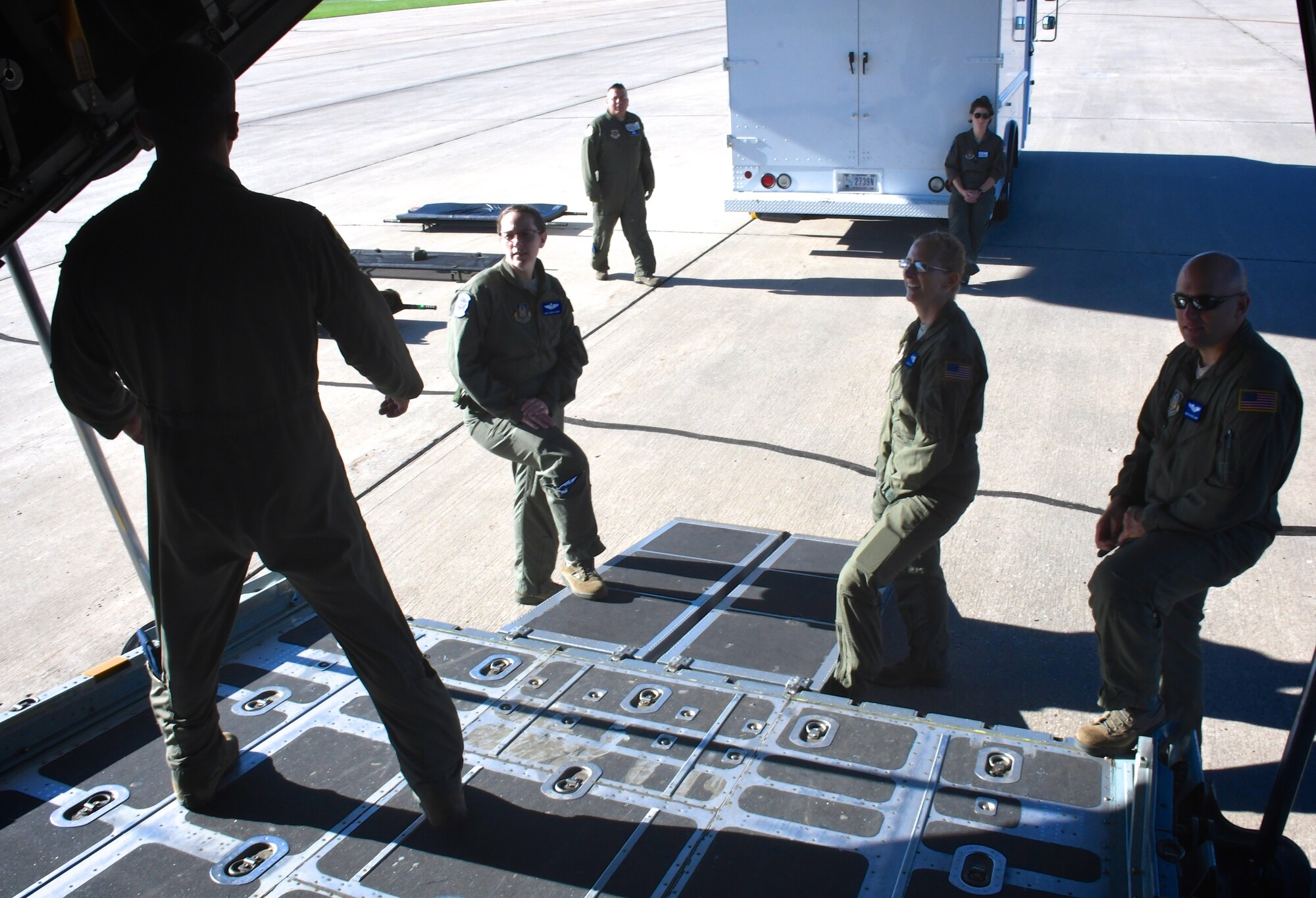 A pilot speaks to 932nd Aeromedical Evacuation Squadron medical members as they make final arrangements to carry medical equipment up a C-130 ramp.  They worked together with ground crew, preparing to fly with "simulated patients" during a training flight, July 21, 2018 at Scott Air Force Base, Ill. The AES trained alongside fellow nurses and medical technicians on a multi day flight aboard a C-130 aircraft visiting from the 910th Airlift Wing of Youngstown, Ohio. The 932nd Airlift Wing is a 22nd Air Force unit, under the Air Force Reserve Command, and is located at Scott Air Force Base, Ill. (U.S. Air Force photos by Lt. Col. Stan Paregien)