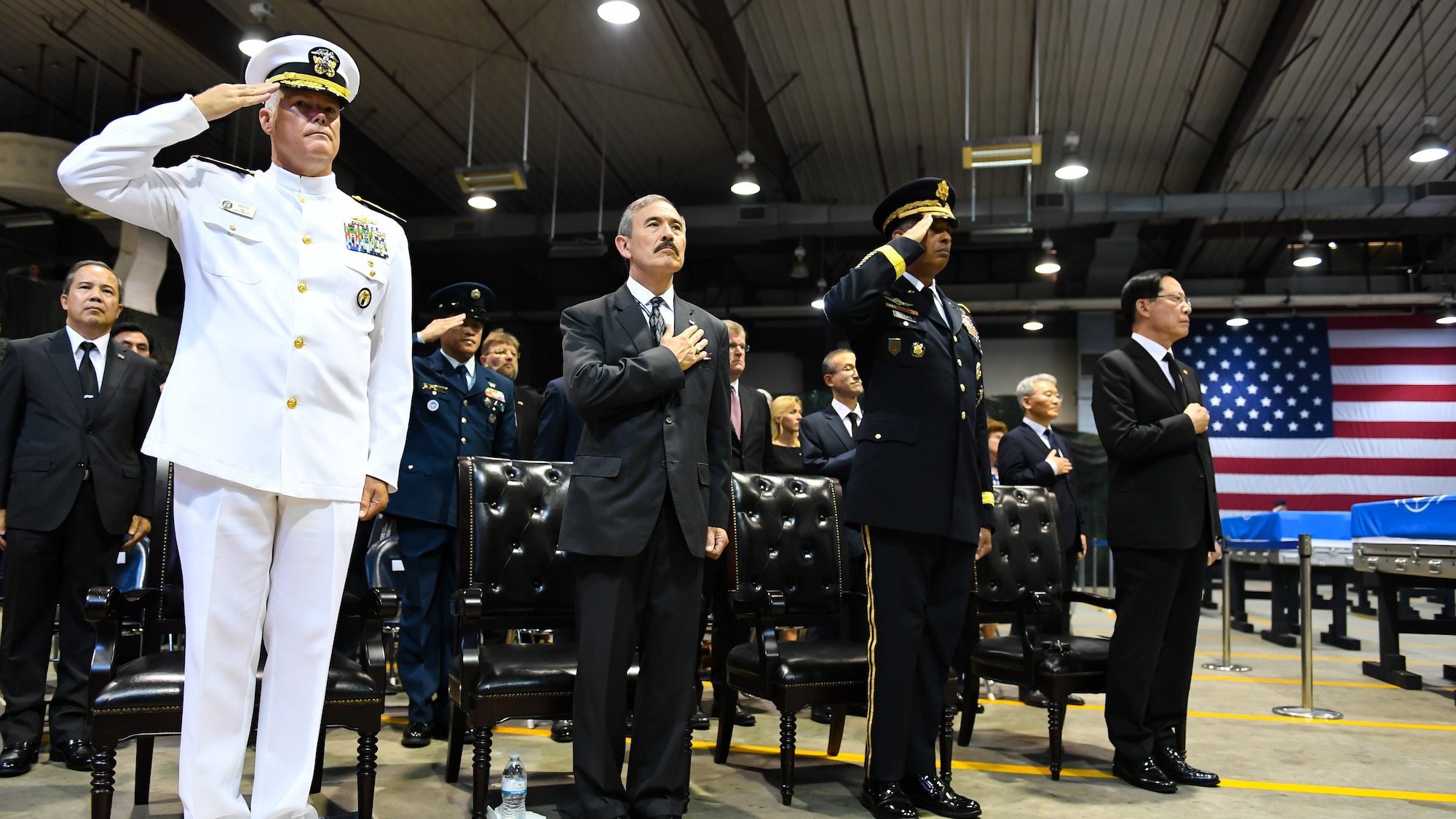 Rear Admiral Jon Kreitz, Deputy Director of Operations for Defense Prisoner of War/Missing in Action Accounting Agency, left, Harry Harris, U.S. Ambassador to the Republic of Korea, center left, General Vincent Brooks, United States Forces Korea commander, center right, and Song Young-moo, South Korean Minister of Defense, pay their respects during a repatriation ceremony at Osan Air Base, South Korea, Aug. 1, 2018.