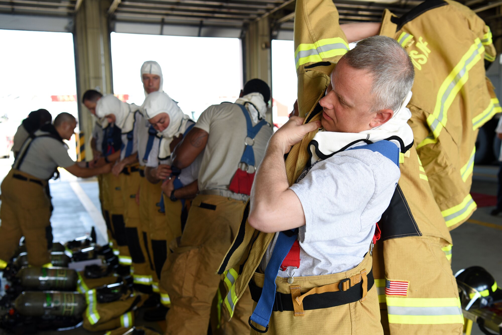 U.S. Air Force Chief Master Sgt. Philip Hudson, 51st Fighter Wing command chief, puts on firefighting gear during an immersion tour with the 51st Civil Engineer Squadron Fire and Emergency Services flight at Osan Air Base, Republic of Korea, Aug. 3, 2018. Wing leadership spent the morning with the firefighters learning about their mission and equipment. (U.S. Air Force photo by Senior Airman Kelsey Tucker)