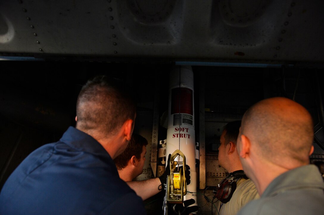 U.S. Airmen assigned to the 86th Aircraft Maintenance Squadron insert a strut into the wheel well of a C-130J Super Hercules on Powidz Air Base, Poland, Aug. 3, 2018. Struts are designed to absorb shock loads upon landing and damp out vertical oscillations. (U.S. Air Force photo by Senior Airman Joshua Magbanua)