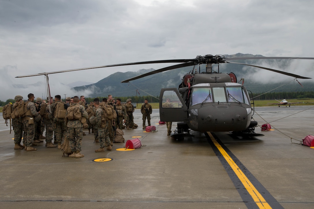 Marines competing in the 4th Marine Division Annual Rifle Squad Competition, receive lessons on how to properly board and ride in a U.S. Army Sikorsky UH-60 Black Hawk at Joint Base Elmendorf-Richardson, Anchorage, Alaska, August 2, 2018. Super Squad Competitions were designed to evaluate a 14-man infantry squad throughout an extensive field and live-fire evolution. (U.S. Marine Corps photo by Lance Cpl. Samantha Schwoch/released)