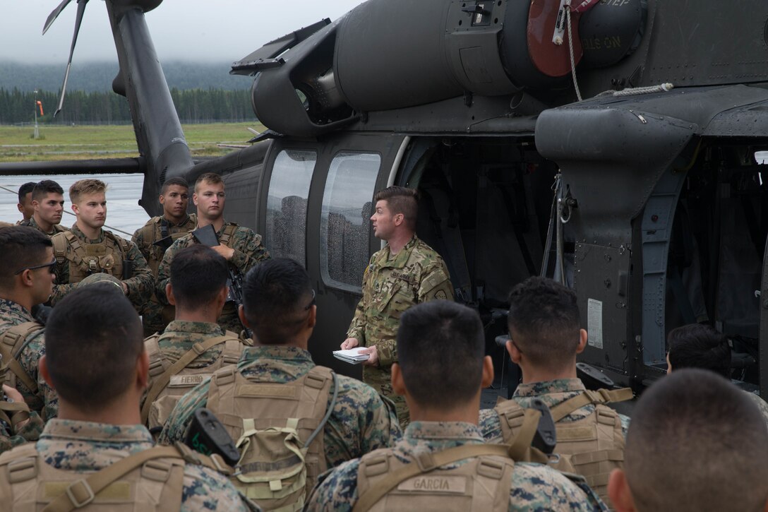 Marines competing in the 4th Marine Division Annual Rifle Squad Competition, receive lessons on how to properly board and ride in a U.S. Army Sikorsky UH-60 Black Hawk at Joint Base Elmendorf-Richardson, Anchorage, Alaska, August 2, 2018. Super Squad Competitions were designed to evaluate a 14-man infantry squad throughout an extensive field and live-fire evolution. (U.S. Marine Corps photo by Lance Cpl. Samantha Schwoch/released)