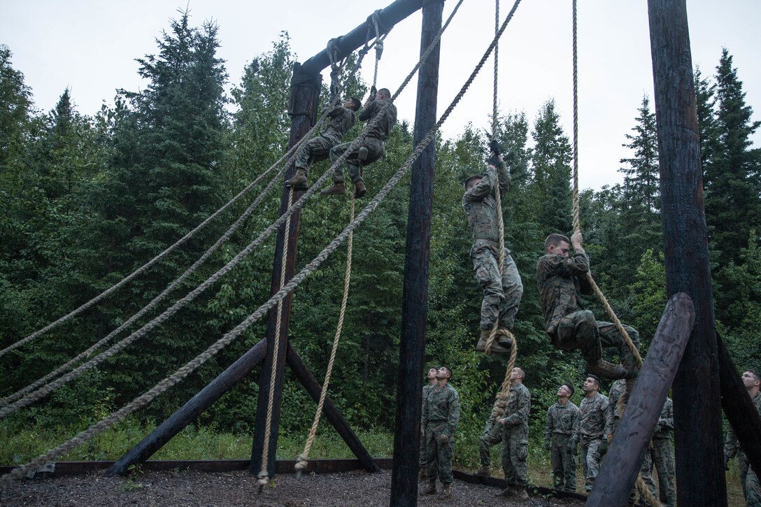 Marines with Charlie Company, 1st Battalion, 23rd Marine Regiment, competing in the 4th Marine Division Annual Rifle Squad Competition, tackle a two-hour timed obstacle course at Joint Base Elmendorf-Richardson, Anchorage, Alaska, August 3, 2018. Super Squad Competitions were designed to evaluate a 14-man infantry squad throughout an extensive field and live-fire evolution. (U.S. Marine Corps photo by Lance Cpl. Samantha Schwoch/released)