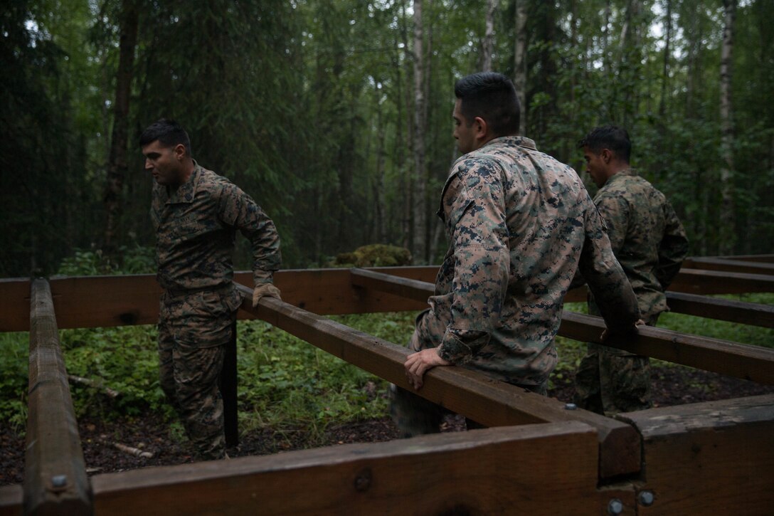 Marines with Charlie Company, 1st Battalion, 23rd Marine Regiment, competing in the 4th Marine Division Annual Rifle Squad Competition, tackle a two-hour timed obstacle course at Joint Base Elmendorf-Richardson, Anchorage, Alaska, August 3, 2018. Super Squad Competitions were designed to evaluate a 14-man infantry squad throughout an extensive field and live-fire evolution. (U.S. Marine Corps photo by Lance Cpl. Samantha Schwoch/released)