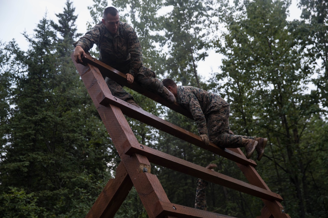 Marines with Charlie Company, 1st Battalion, 23rd Marine Regiment, competing in the 4th Marine Division Annual Rifle Squad Competition, tackle a two-hour timed obstacle course at Joint Base Elmendorf-Richardson, Anchorage, Alaska, August 3, 2018. Super Squad Competitions were designed to evaluate a 14-man infantry squad throughout an extensive field and live-fire evolution. (U.S. Marine Corps photo by Lance Cpl. Samantha Schwoch/released)