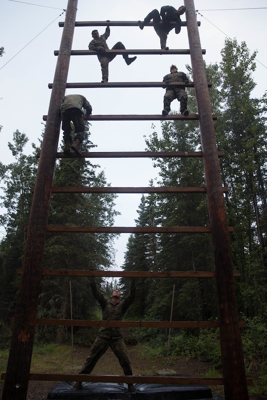 Marines with Charlie Company, 1st Battalion, 23rd Marine Regiment, competing in the 4th Marine Division Annual Rifle Squad Competition, tackle a two-hour timed obstacle course at Joint Base Elmendorf-Richardson, Anchorage, Alaska, August 3, 2018. Super Squad Competitions were designed to evaluate a 14-man infantry squad throughout an extensive field and live-fire evolution. (U.S. Marine Corps photo by Lance Cpl. Samantha Schwoch/released)