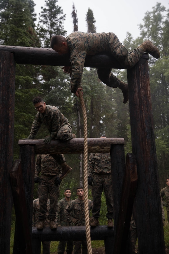 Marines with Charlie Company, 1st Battalion, 23rd Marine Regiment, competing in the 4th Marine Division Annual Rifle Squad Competition, tackle a two-hour timed obstacle course at Joint Base Elmendorf-Richardson, Anchorage, Alaska, August 3, 2018. Super Squad Competitions were designed to evaluate a 14-man infantry squad throughout an extensive field and live-fire evolution. (U.S. Marine Corps photo by Lance Cpl. Samantha Schwoch/released)