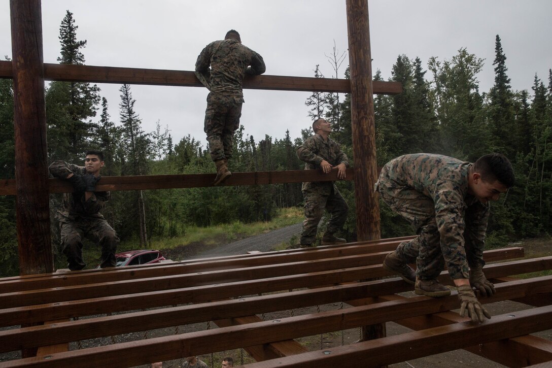 Marines with Charlie Company, 1st Battalion, 23rd Marine Regiment, competing in the 4th Marine Division Annual Rifle Squad Competition, tackle a two-hour timed obstacle course at Joint Base Elmendorf-Richardson, Anchorage, Alaska, August 3, 2018. Super Squad Competitions were designed to evaluate a 14-man infantry squad throughout an extensive field and live-fire evolution. (U.S. Marine Corps photo by Lance Cpl. Samantha Schwoch/released)