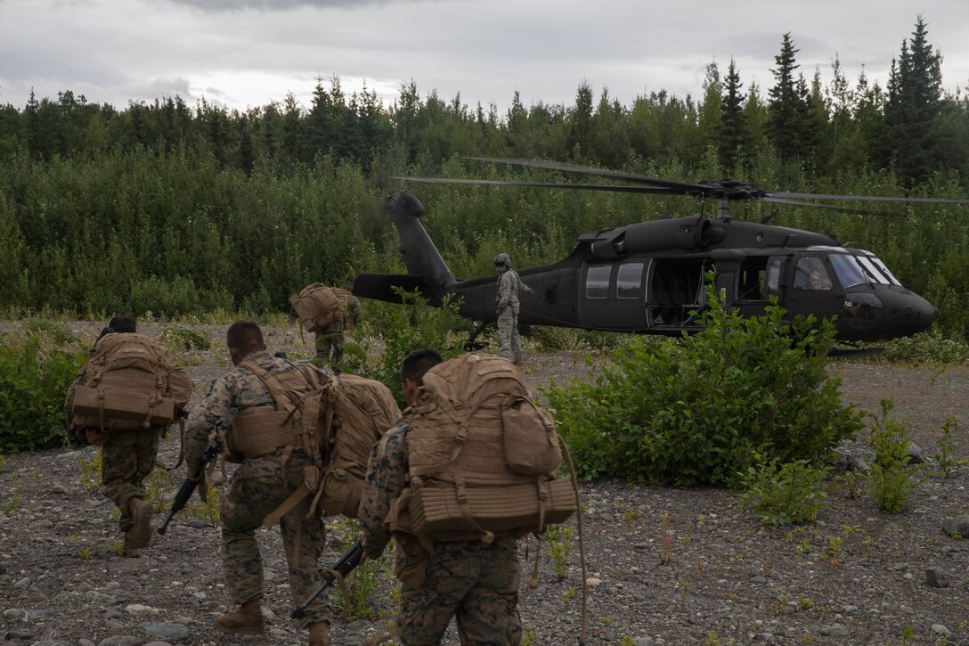 Marines with Charlie Company, 1st Battalion, 23rd Marine Regiment, competing in the 4th Marine Division Annual Rifle Squad Competition, make their way to a U.S. Army Sikorsky UH-60 Black Hawk at Joint Base Elmendorf-Richardson, Anchorage, Alaska, Aug. 3, 2018. Super Squad Competitions were designed to evaluate a 14-man infantry squad throughout an extensive field and live-fire evolution. (U.S. Marine Corps photo by Lance Cpl. Samantha Schwoch/released)