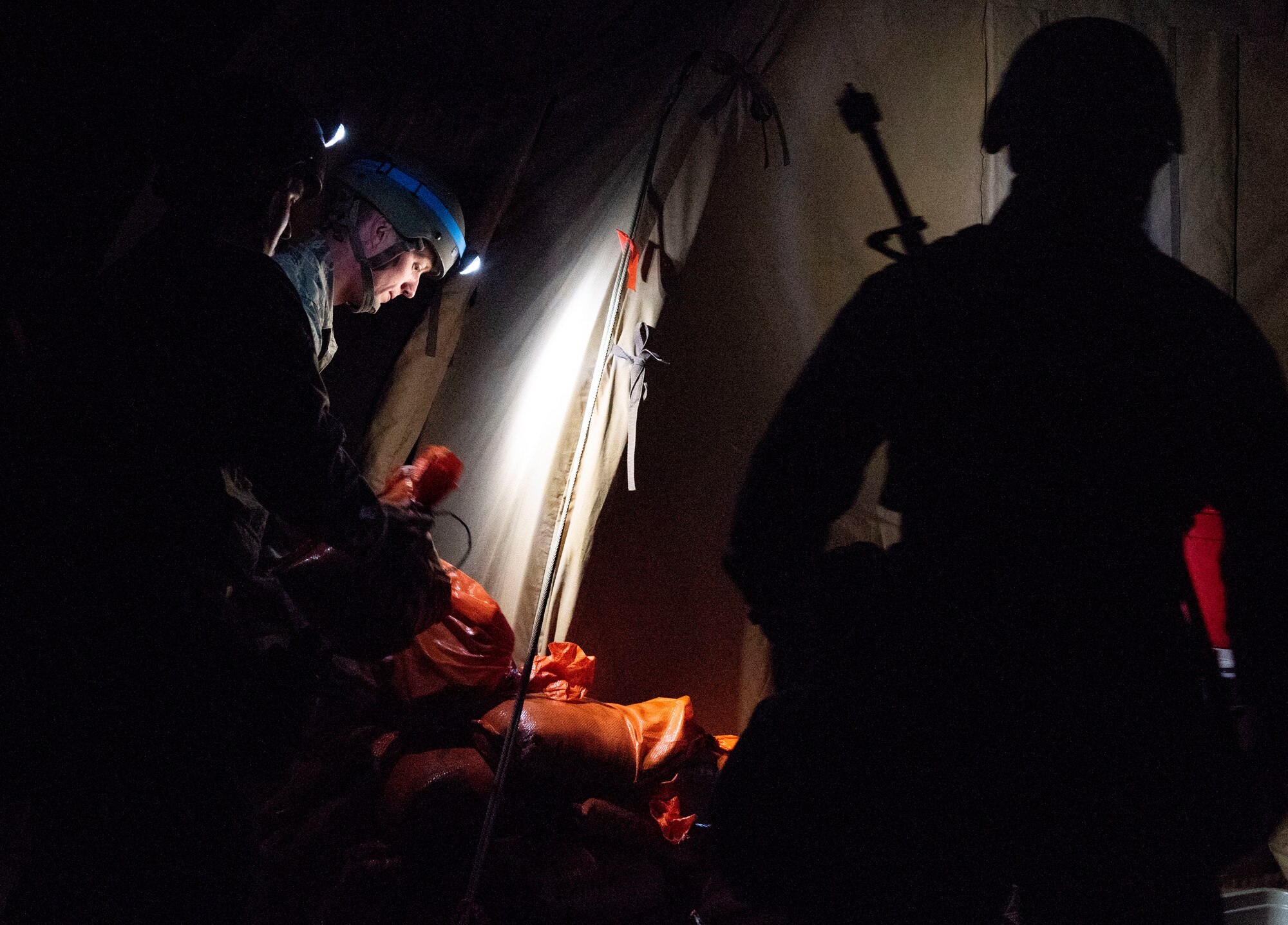 Airmen with the 375th Civil Engineer Squadron harden a shelter during a base exercise, Aug. 1, 2018, at Scott Air Force Base, Illinois. These Airmen were responding to several simulated explosions and ensuring the training area was prepared for possible impending explosions. (U.S. Air Force photo by Airman 1st Class Tara Stetler)
