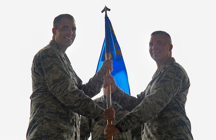 Lt. Col. Joseph Beal, 437th Operations Support Squadron incoming commander, passes the 437th OSS guidon to Col. Daniel Dobbels, 437th Operations Group commander, during a change of command ceremony Aug. 3, 2018 at Joint Base Charleston. The 437th OSS is responsible for airfield management, life support services, flight records management, weather and intelligence support, airlift scheduling, tactical employment and aircrew training for approximately 1,400 active and reserve service members.