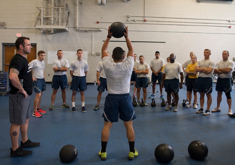 Airman 1st Class Eddie Delgado, an aircrew flight equipment inspector with the 437th Operations Support Squadron, demonstrates a slam ball squat throw during the Alpha Warrior Air Force Fitness Tour Level 1 Battle Rig Instructor Course Aug. 1, 2018, at the Fitness Center at Joint Base Charleston, S.C.