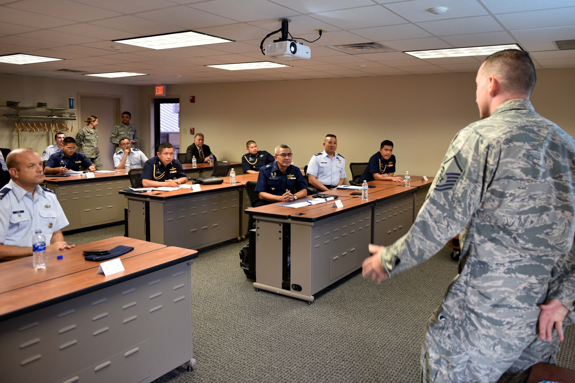 U.S. Air Force Master Sgt. Martin Smith, 315th Training Squadron flight chief, addresses Pacific Air Forces and Royal Thai air force leaders on how the base trains geospatial intelligence professionals in the International Intelligence Training Center on Goodfellow Air Force Base, Texas, Aug. 2, 2018. The IITC, which opened in January 2018, provides the International Intelligence Applications Officer Course. (U.S. Air Force photo by Senior Airman Randall Moose/Released)