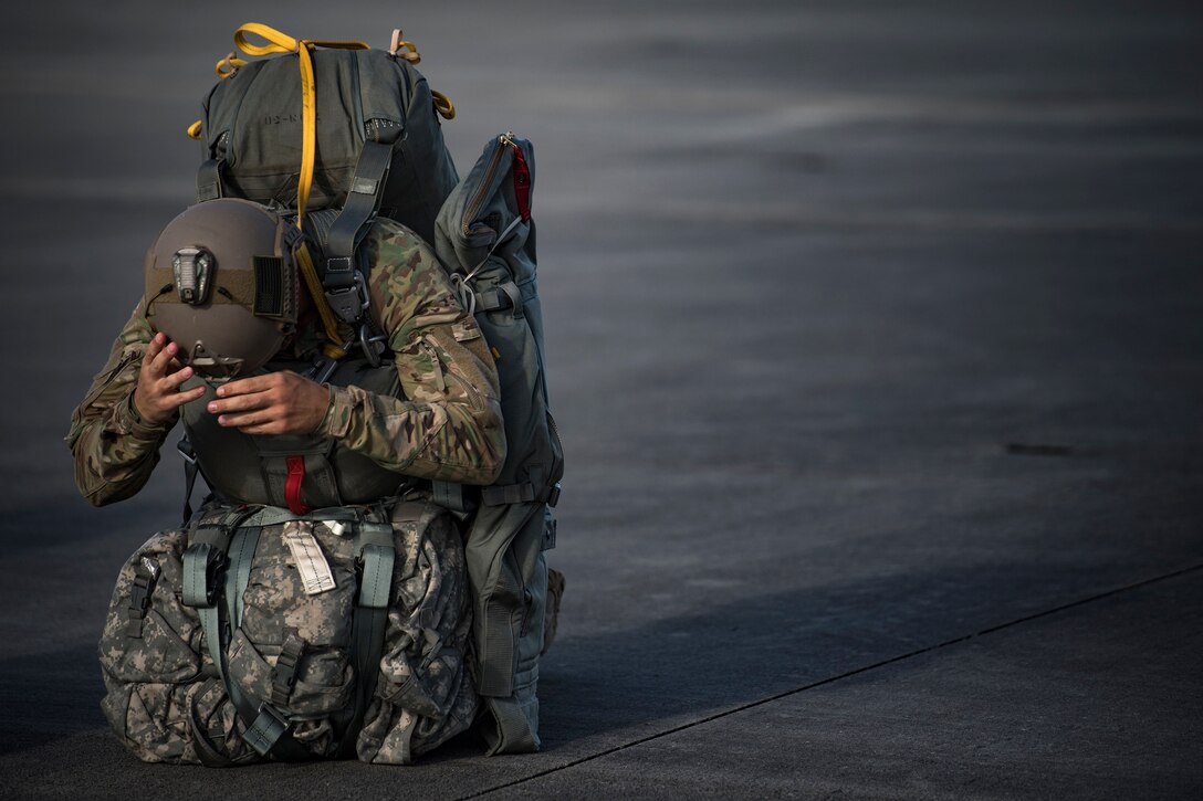 Senior Airmen Alex Carver, 824th Base Defense Squadron fireteam member, dons his helmet prior to a static-line jump, July 31, 2018, at Moody Air Force Base, Ga. The 820th Base Defense Group includes airborne-qualified Airmen to bolster its worldwide-deployable force-protection capability and requires them to jump periodically to maintain their qualification. (U.S. Air Force photo by Staff Sgt. Ryan Callaghan)