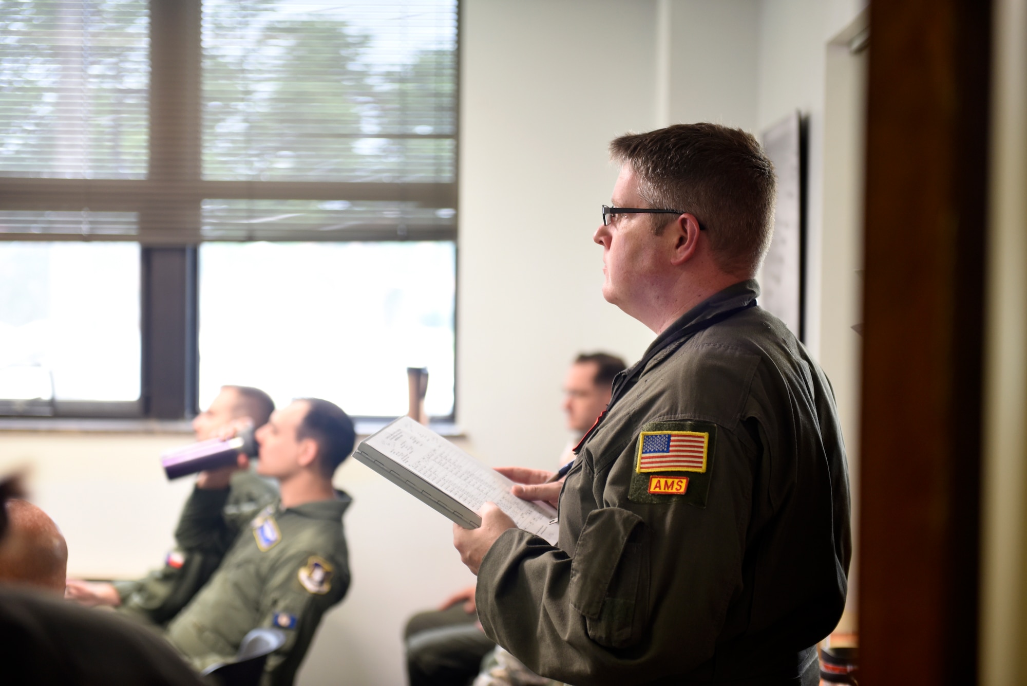 U.S. Air Force Tech. Sgt. Cody Niemi, 97th Intelligence Squadron, listens to a  preflight briefing before departing for a weekend training sortie at Offutt Air Force Base, Nebraska Aug. 5, 2018. The objective of the briefing is to communicate a common operating picture of meteorological and aeronautical information to the entire crew necessary for the conduct of a safe and efficient flight. (U.S. Air Force photo by 2nd Lt. Drew Nystrom)
