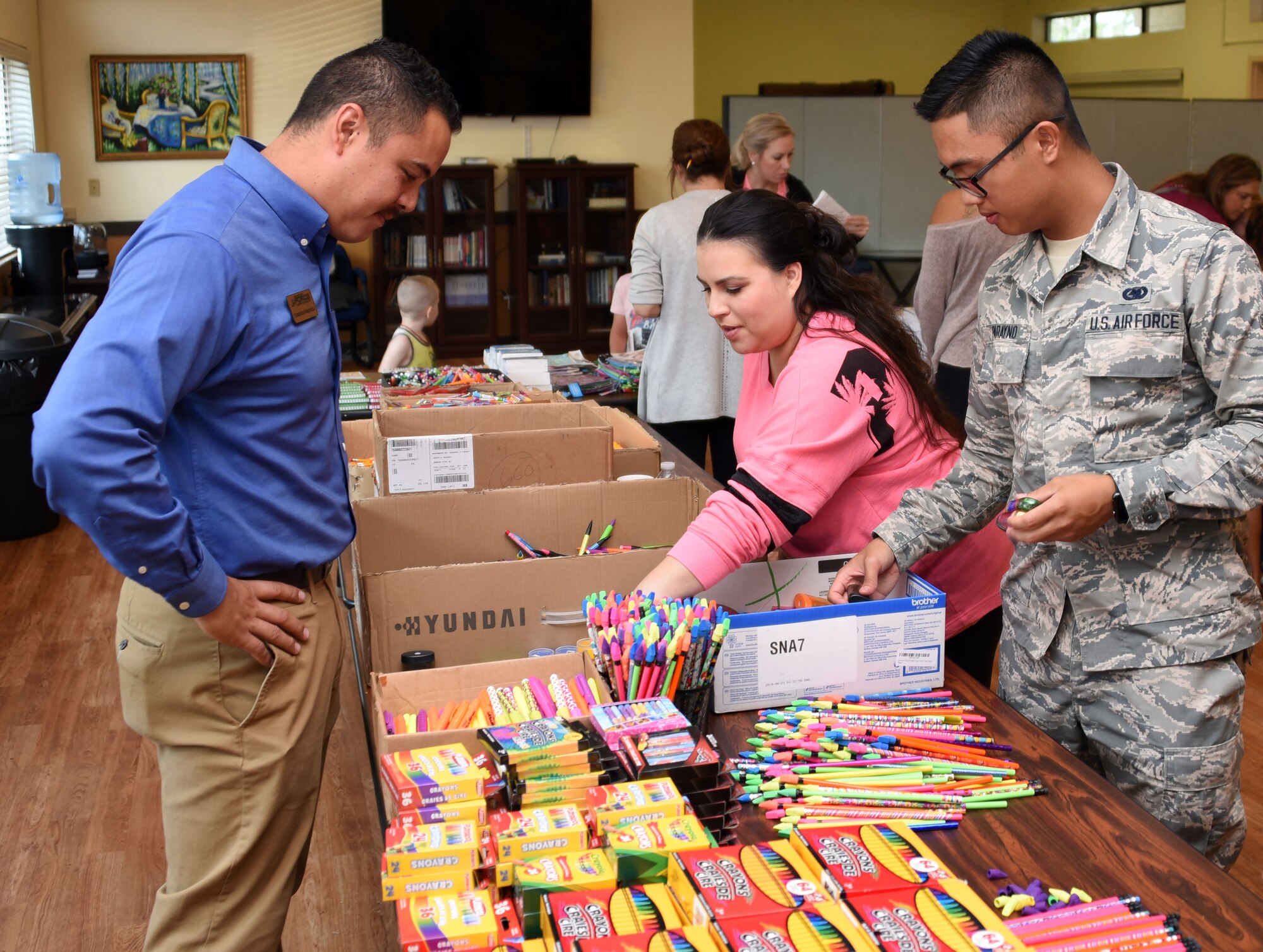 Christian Mendoza, 60th Force Support Squadron school liaison, left, surveys the choices Travis students have to choose from during Operation Homefront’s “Back to School Brigade” Aug. 2 at the base’s First Street Chapel. The event helped to provide children of E-1 to E-6 Airmen with free school supplies for the upcoming academic year. (U.S. Air Force photo by Airman 1st Class Christian Conrad)